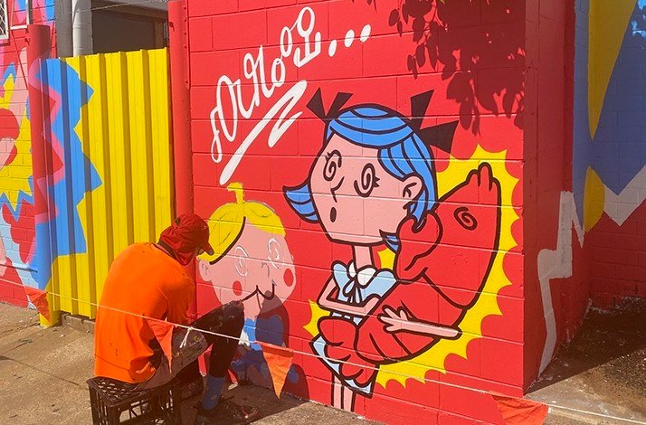 A street painter working on a large-scale street art .