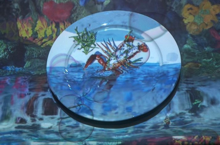 A plate featuring a cooked lobster is displayed prominently on a screen.