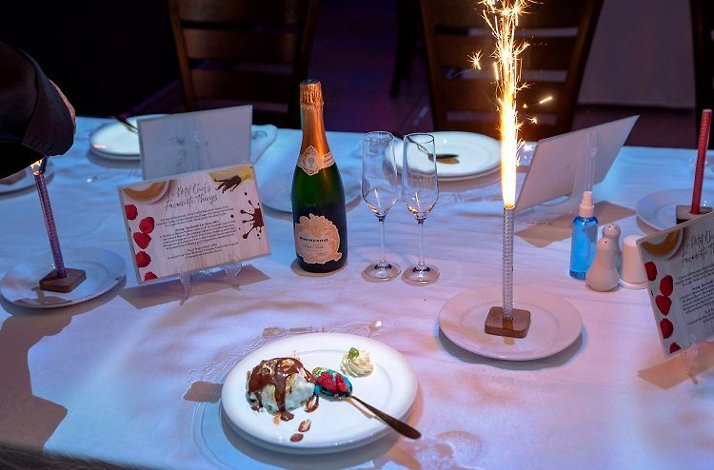 A table set with a decorated cake topped with candles, ready for a celebration.