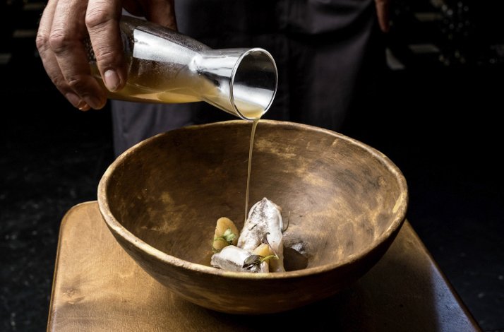 The close shot of a freshly prepared Spanish haute cuisine dish, accompanied by the sauce being poured, served at Corral de la Morería.