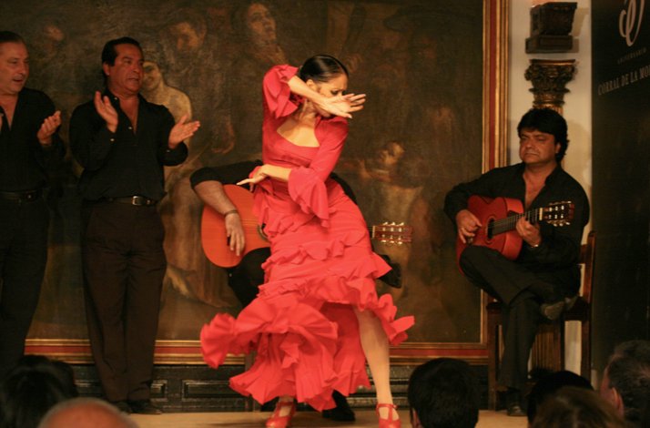 An artist in a red dress dancing flamenco