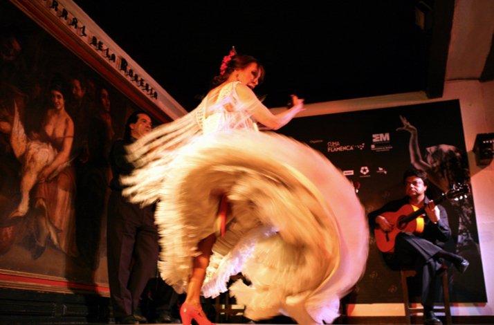 An artist in a white dress dancing flamenco