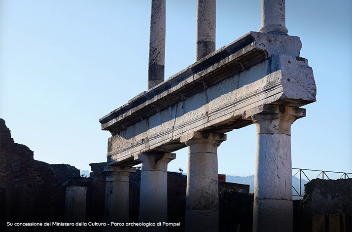 Two-story colonnade at the Forum in Pompeii, Italy, showing fluted Doric columns supporting a stone architrave.