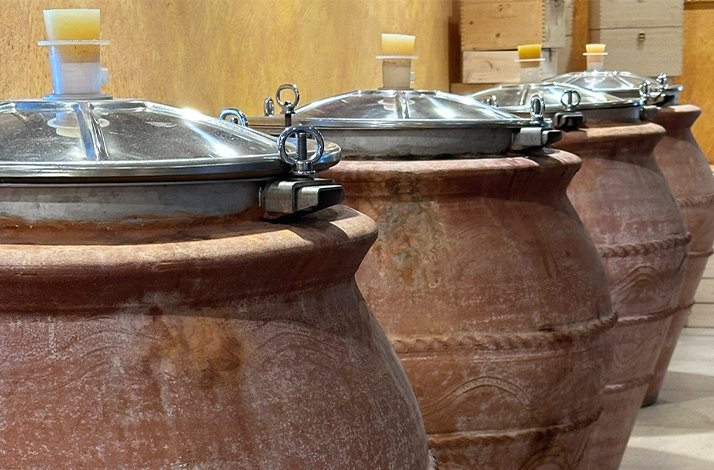 A row of large, lidded pots arranged neatly in a line, showcasing their uniform size and shape.