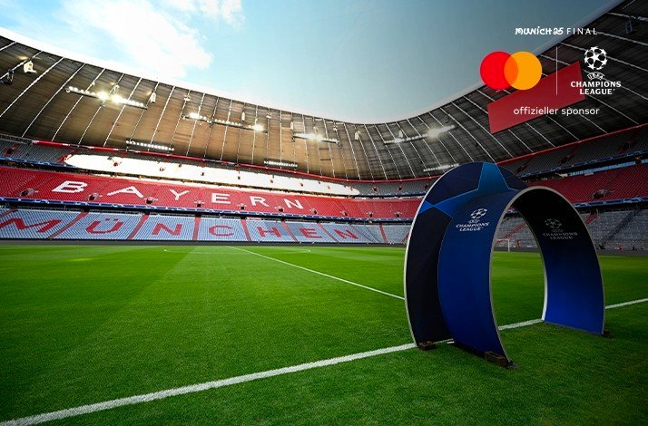 A blue arch with UEFA Champions League logo photographed on a football field