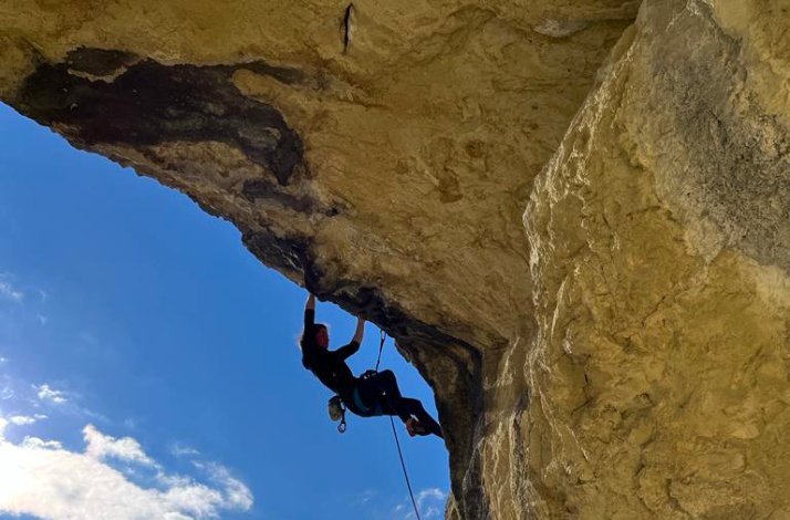 A participant climbing a mountain with special equipment and belay