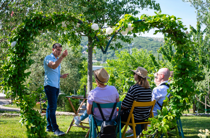 A guide leads an outdoor educational tour for a seated group at the Stella Croatica estate in Klis.