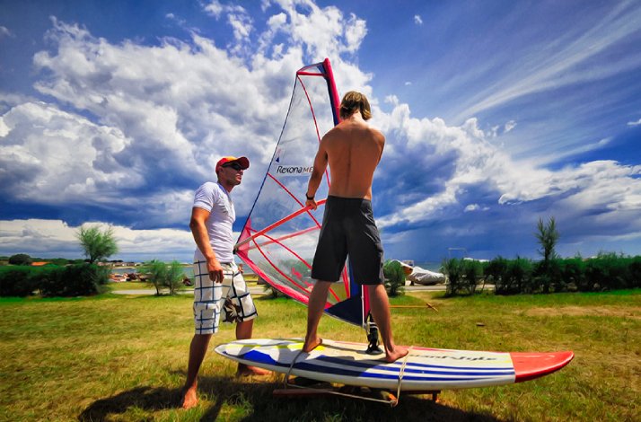 An instructor from Tsunami Windsurfing showing a participant how to stand on a board