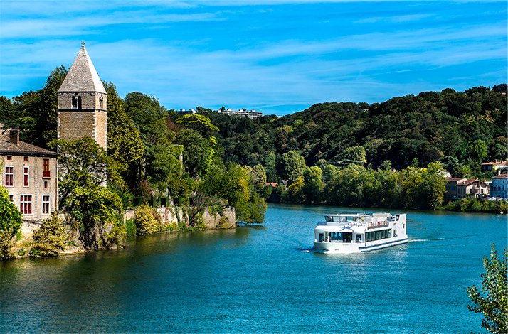 Soak up Lyon's picturesque landscapes on a dining cruise with Les Bateaux Lyonnais: In Lyon, France Cruise boat passing along picturesque riverbanks of Lyon.