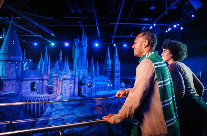 2 people overlooking a model of Hogwarts during Warner Bros. Studio Tour in London.