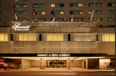 Exterior of Fairmont Le Reine Elizabeth hotel entrance at night with lit gold signage in Montreal, Canada.