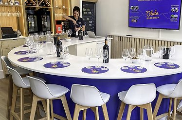 The lady is opening a wine bottle for the upcoming workshop