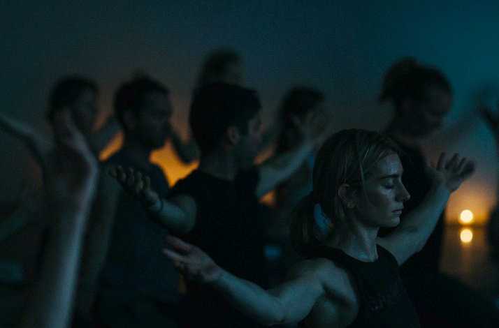 Group of people doing yoga in a dimly lit room