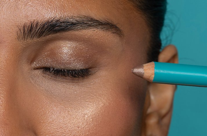 Close-up of a model applying Brown Topaz eyeliner by Cheekbone Beauty.