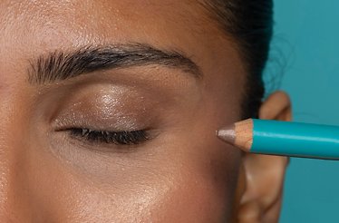 Close-up of a model applying Brown Topaz eyeliner by Cheekbone Beauty.