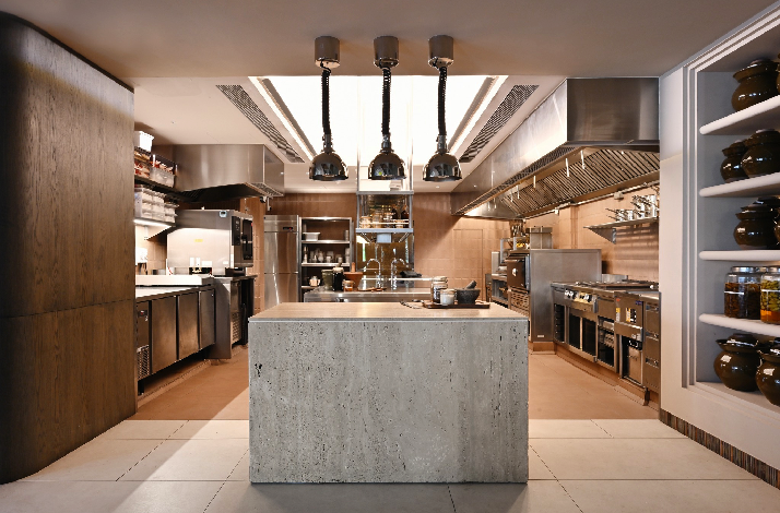 Fiz restaurant modern open kitchen with central island and stainless steel appliances.