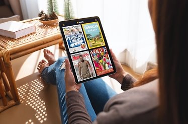 A woman reading from her tablet at home on a sunny day