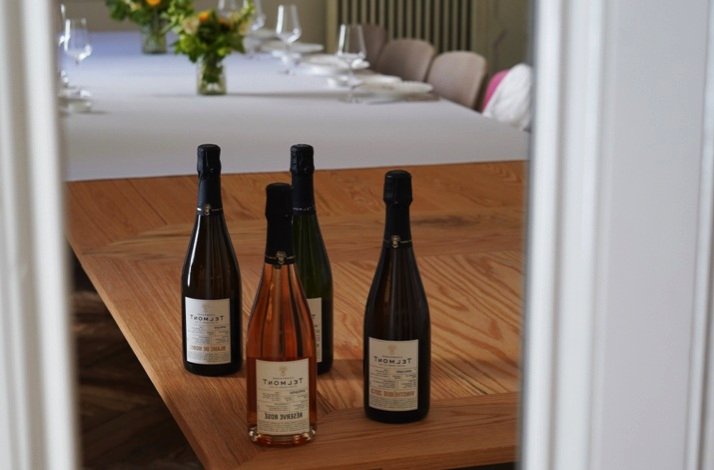 Four wine bottles arranged on a wooden table in a softly lit private tasting room at Club Matador.