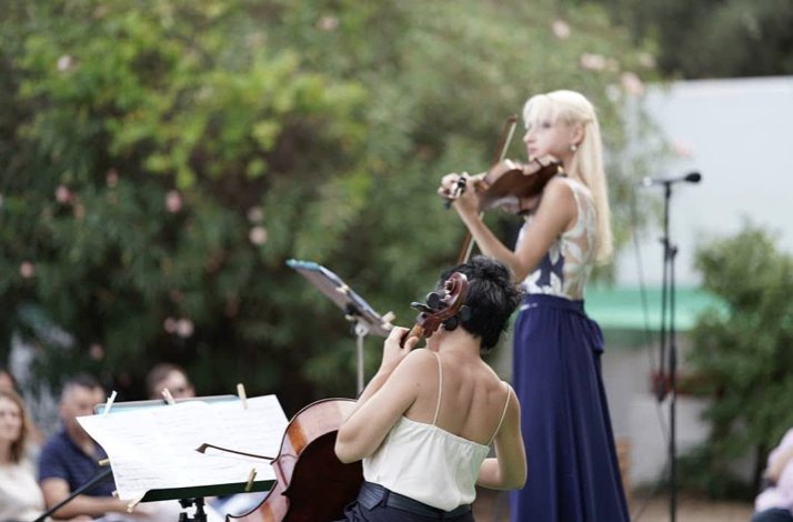 Violinist Elina Sitnikava and cellist Marta Mulero performing outdoors