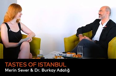 Merin Sever and Dr. Burkay Adalığ sitting in yellow armchairs in a white room during the discussion about the civilizations that have shaped the unique flavors of Istanbul.