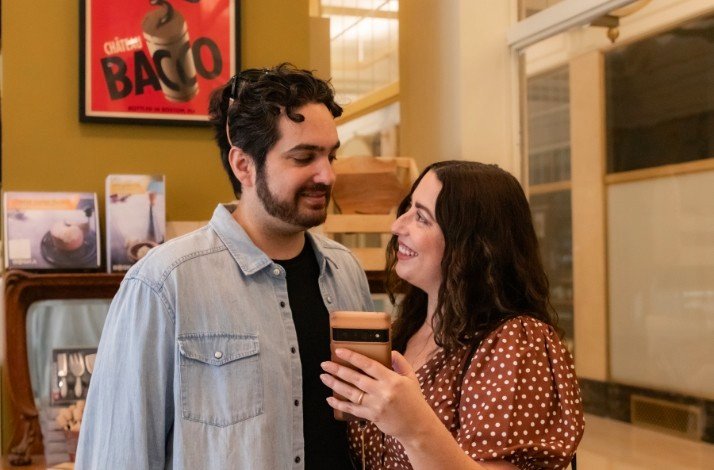 A girl is showing her phone to a guy smiling.
