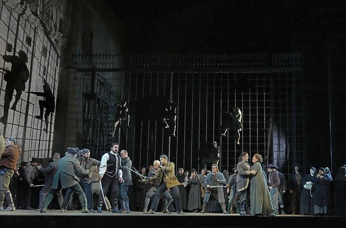 Actors interpreting a sword fight live on stage.