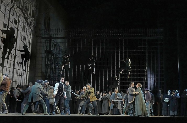 Actors interpreting a sword fight live on stage.