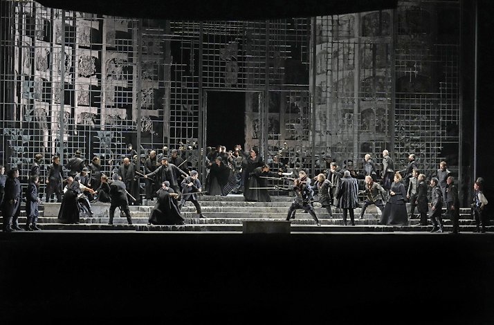 Actors interpreting a sword fight live on stage.