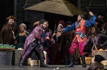 Actors interpreting a sword fight live on stage.