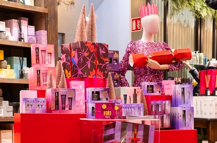 Avoca Suffolk Street Christmas gift display featuring Caudalie gift sets, mini trees, and a sequined mannequin holding a cracker.