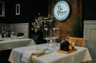 The interior of restaurant DaPino with its logo on the wall.