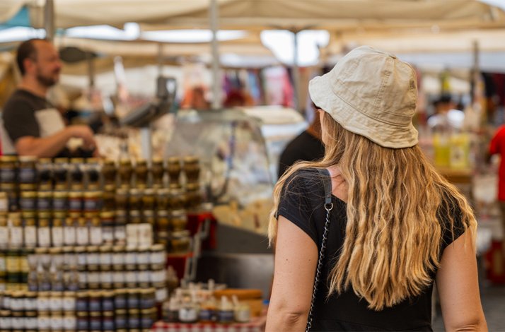 A woman exploring a food market on a culinary walking tour in Rome.