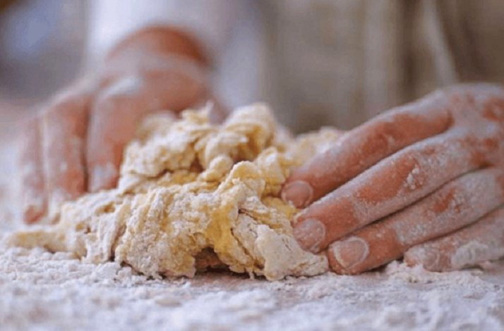 Hands kneading dough for pasta.