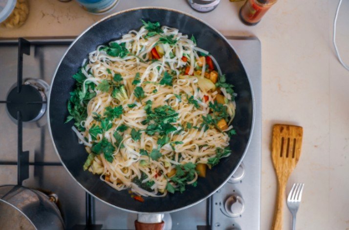 Pad Thai being cooked in a wok during a cooking class with Chef Saruj