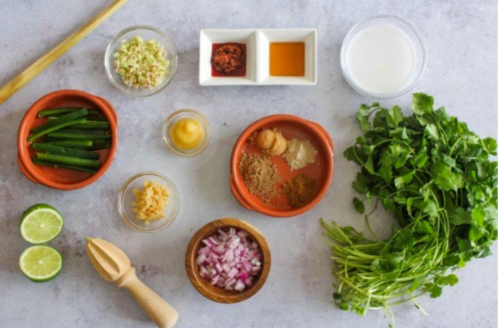 Ingredients for Thai green curry: chopped onions, various spices, parsley, green beans, lime, coconut milk.