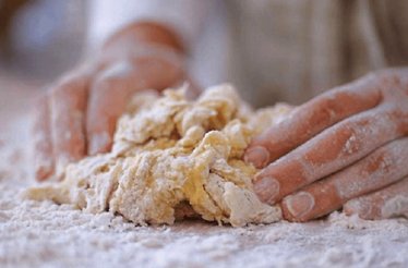 Hands kneading dough for pasta.