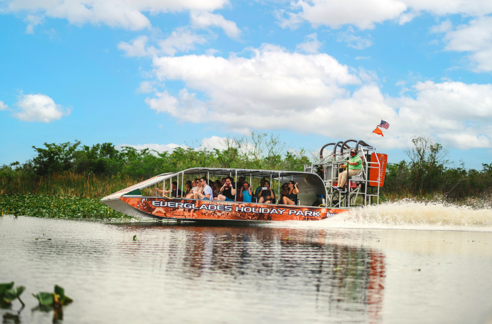 A group of people riding through Everglades on a boat.