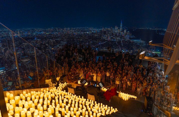 Candle‑lit outdoor concert above the city.