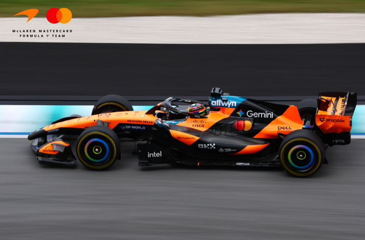 McLaren F1 car speeding on a racetrack.