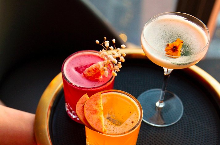 Dine above the clouds with preferred table reservations at Peak with Priceless: In New York, New York Tray with three colorful cocktails served at Peak restaurant.