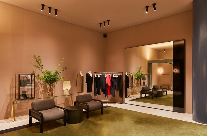 A stylish boutique with contemporary furniture, clothing racks, and minimalist decor.