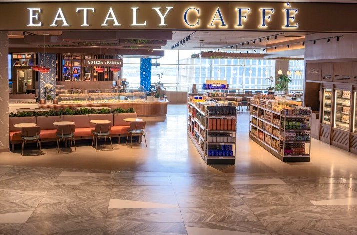 Entrance view of Eataly Caffè with seating and grocery displays.