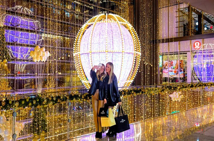 Two people taking pictures near holiday decorations at Hudson Yards