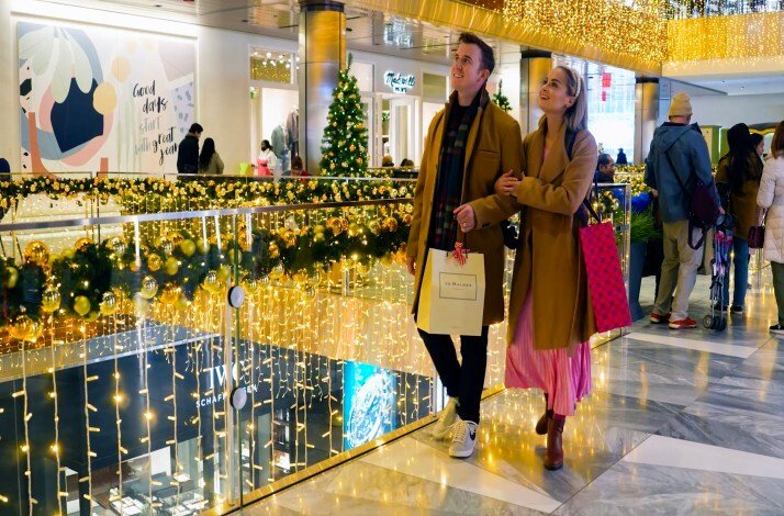 A couple walking through Hudson Yards looking at the holiday decorations