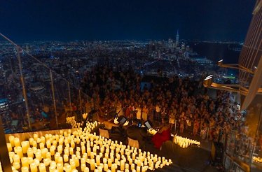 Candle‑lit outdoor concert above the city.