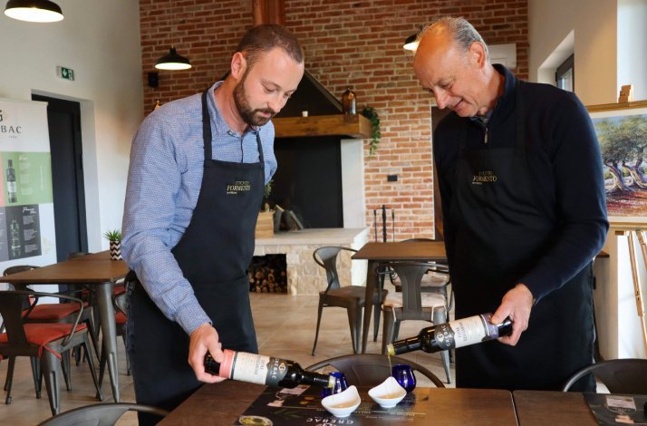 Representatives of the Grebac family pouring olive oil from their own olive groves into tasting bowls in the dining area of Monte Fermento, Kaštelir, Istria.