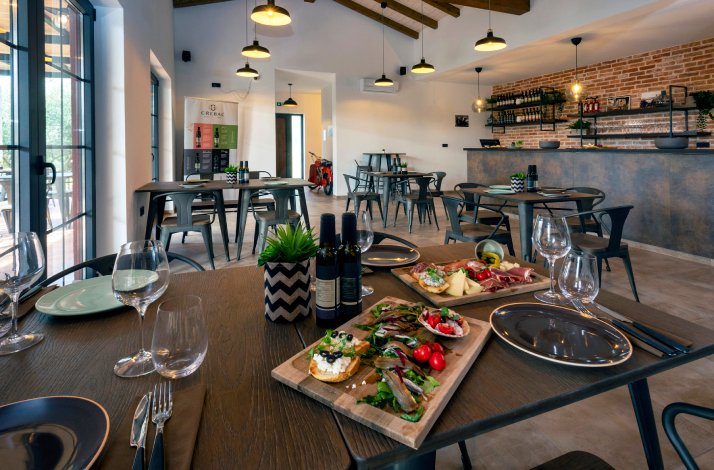Table in the dining area served for tasting of extra virgin olive oil, wine, and produce from Istria on the premises of Monte Fermento.