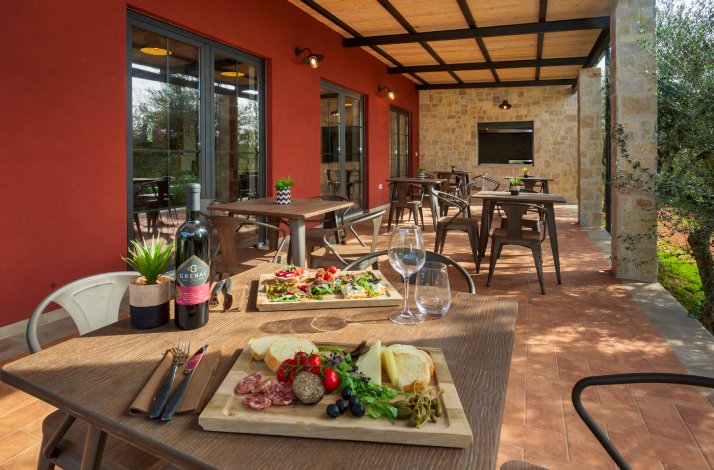 Table on the terrace served for tasting of extra virgin olive oil, wine, and produce from Istria on the premises of Monte Fermento.