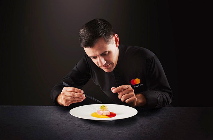British chef Jason Atherton posing for the photo in a chef's uniform with Mastercard logo on it