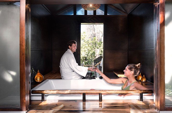 A couple in a hot bath relaxing and drinking lavender milk